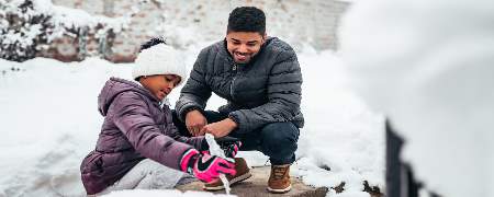 Father and daughter playing in the snow.