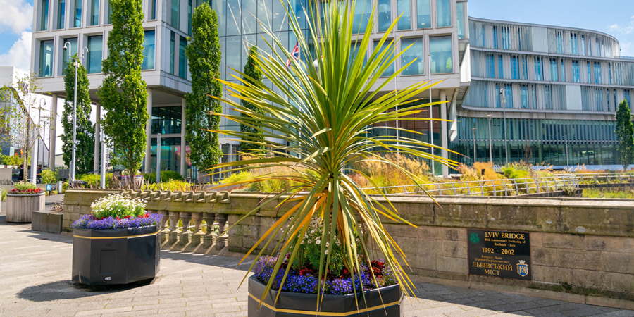 Large pots with flowers and plants in front of Number One Riverside in Rochdale.