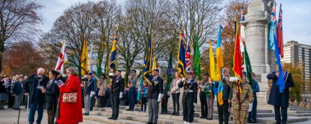 A group of people standing in front of a monument with flags.