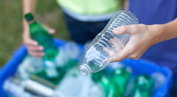 Hands sorting through bottles for recycling.