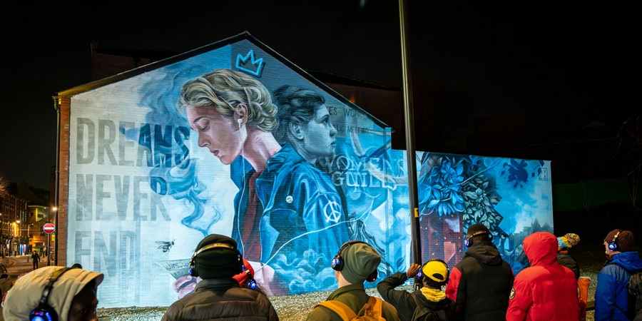 Visitors viewing a mural.