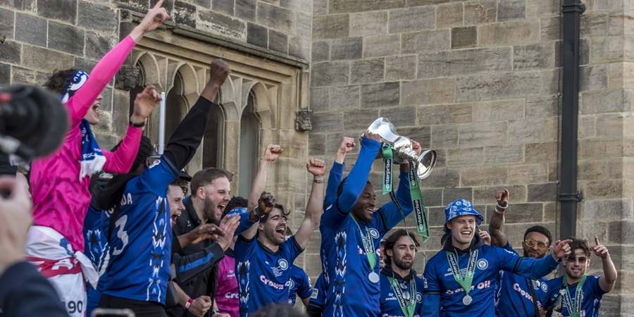 Rochdale AFC players holding trophy.