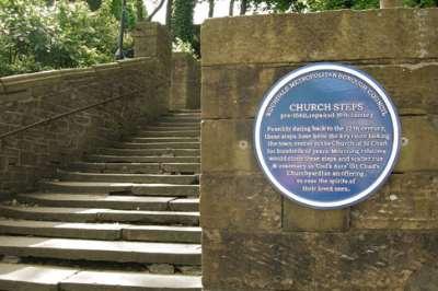 The blue plaque at the foot of the church steps.