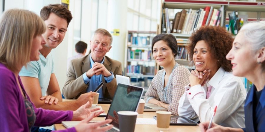 A group of adults talking in a library.