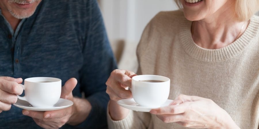 2 adults chatting over coffee.