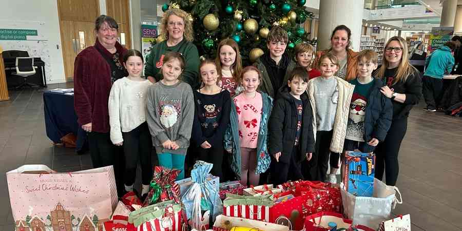 Helen Walton with pupils, staff and parents at Holy Trinity CE School.
