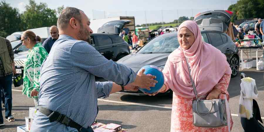 A sales transaction at Bowlee Car Boot Sale.