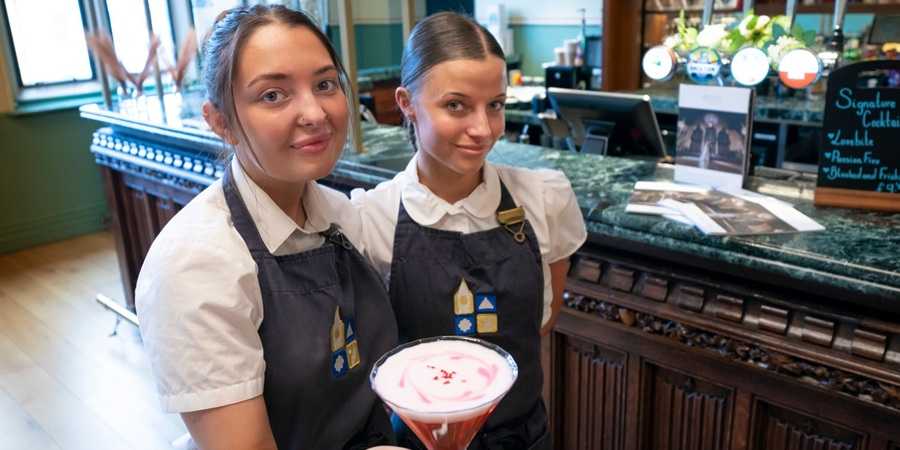 Bartenders with cocktails.