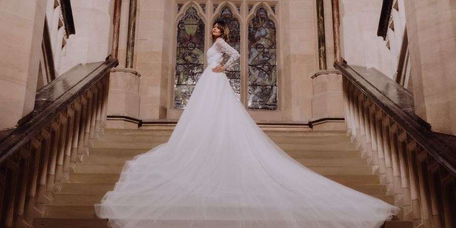 Model wearing a wedding dress, standing on the main staircase in Rochdale Town Hall.