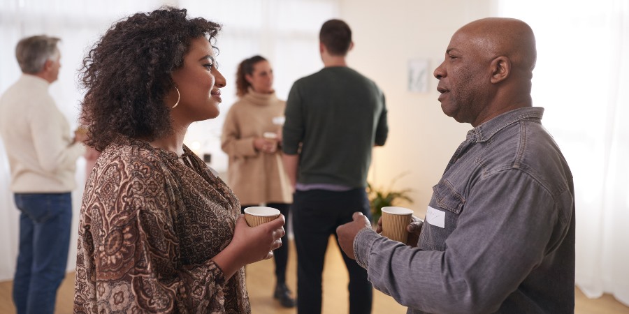 People in conversation over coffee.