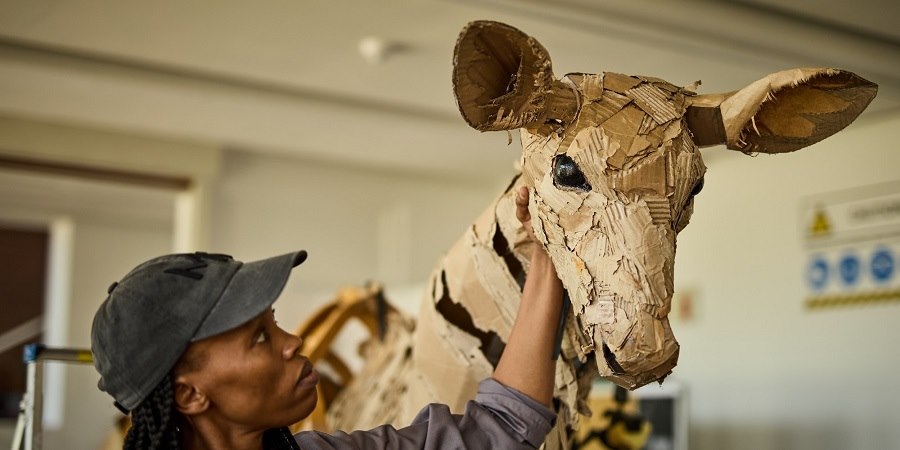 Model maker working on model giraffe.
