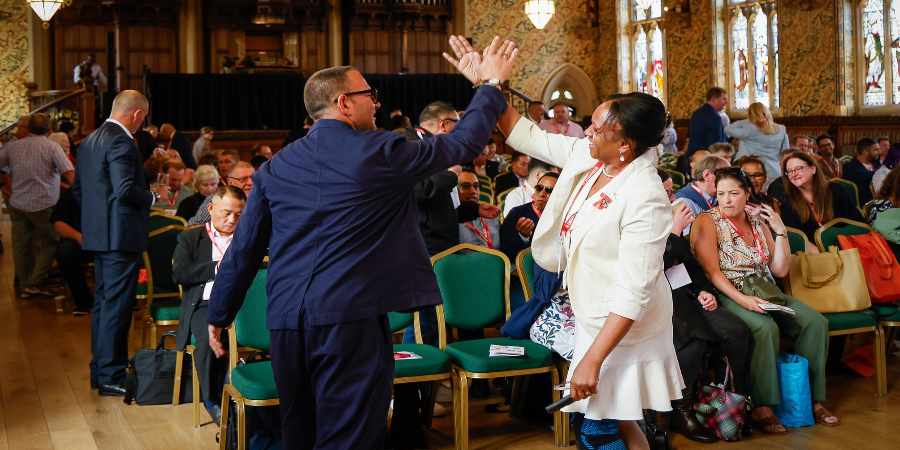 Atrendees linking hands at the Co-operative Congress.
