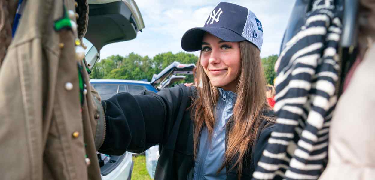 Visitor to Bowlee Car Boot Sale examining clothes for sale.