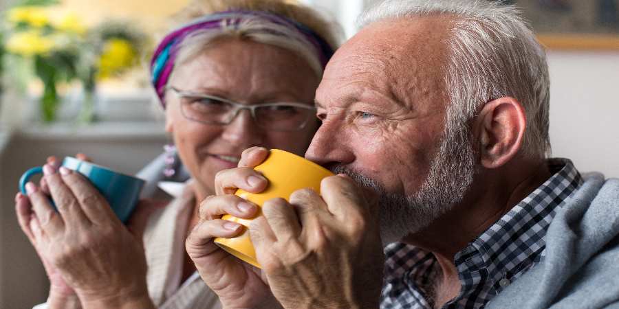 A couple with mugs of tea.