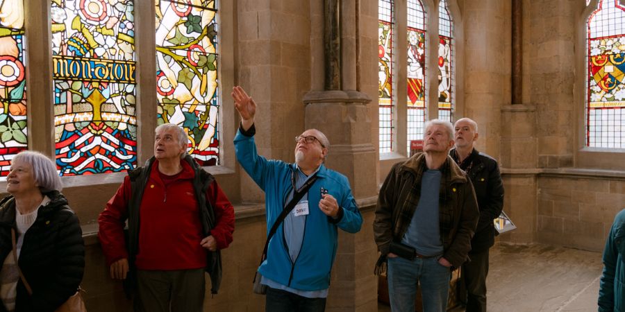 A group of people looking around a large ornate room.