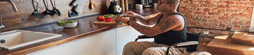 Woman in a wheelchair preparing vegetables.