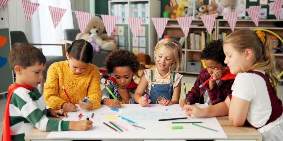 Children sat round a table drawing.