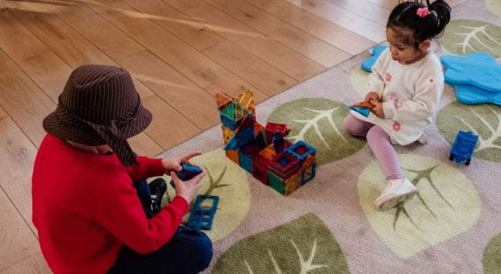 Children playing on rug.