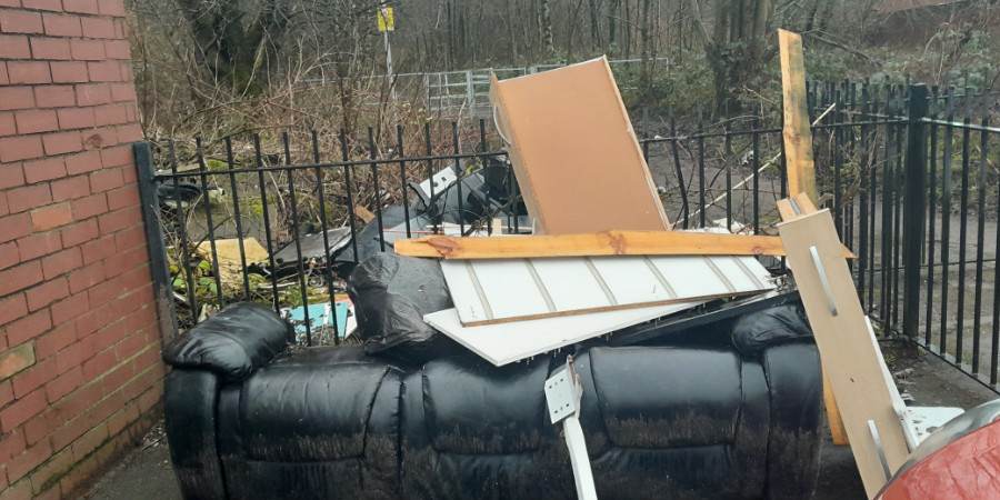 The fly tipped sofa and other rubbish.