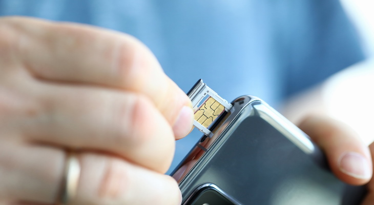 A SIM card being inserted into a mobile phone.