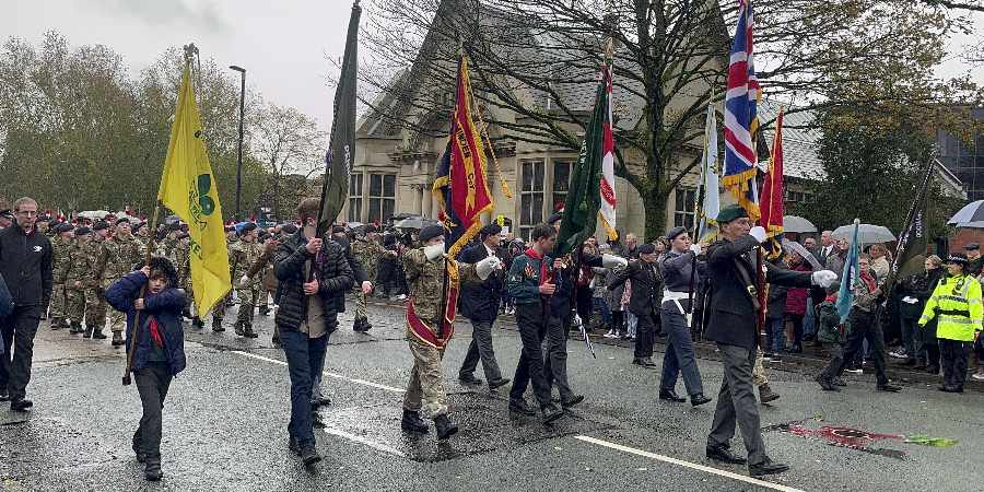 Veterans marching with flags through Heywood town centre.