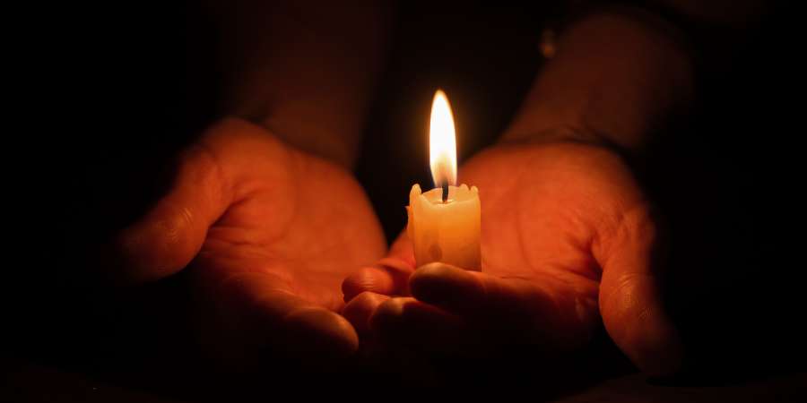 Hands holding a candle.