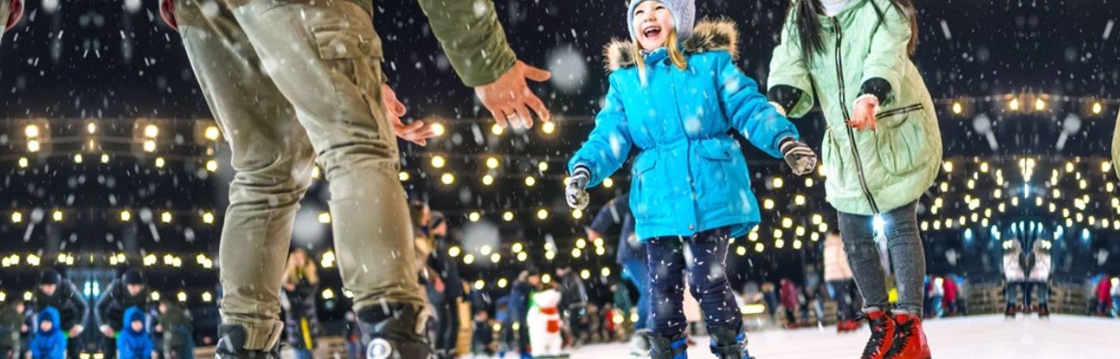 A child ice skating with their parents.