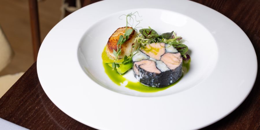 A fish dish with a green sauce.