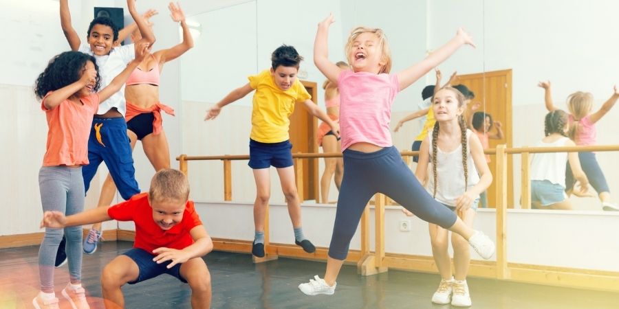 A group of children dancing in a dance studio.