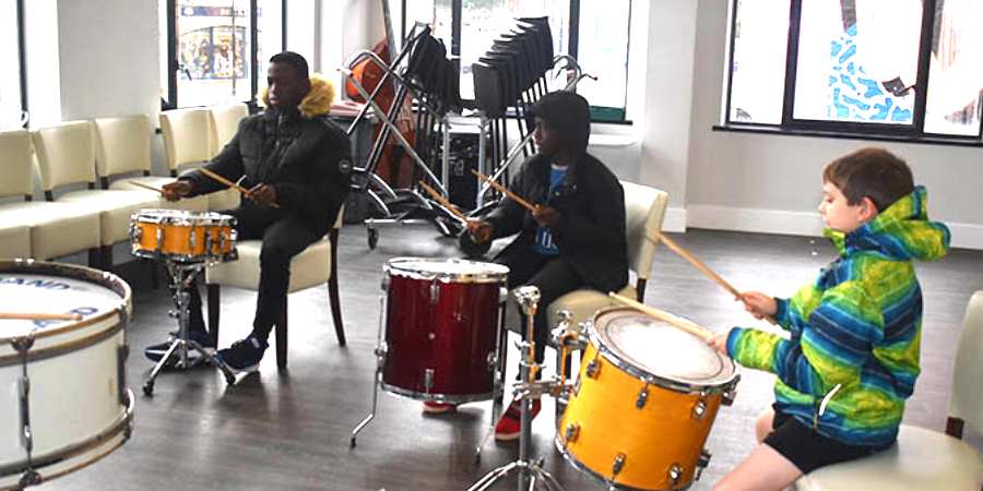 Students playing drums in an untuned percussion lesson. 