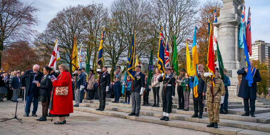 Councillor Neil Emmott, leader of the council, at the Rochdale Cenotaph with veterans holding flags.