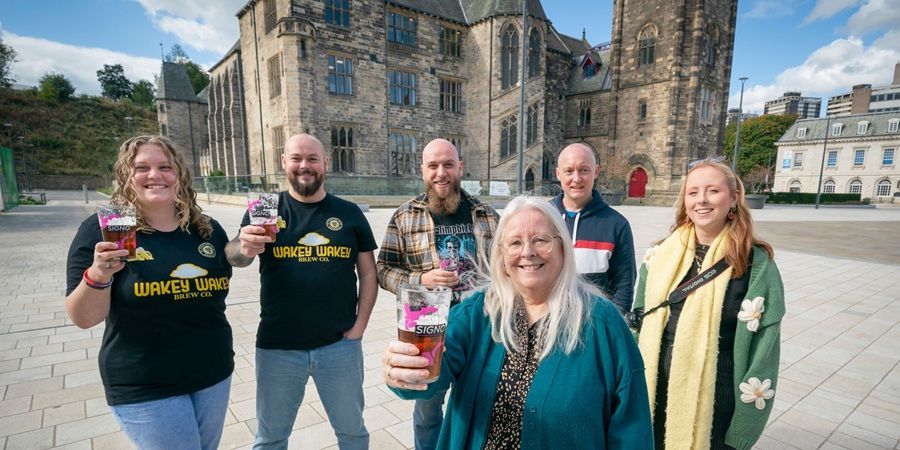 A group of people stood in front of Rochdale Town Hall.