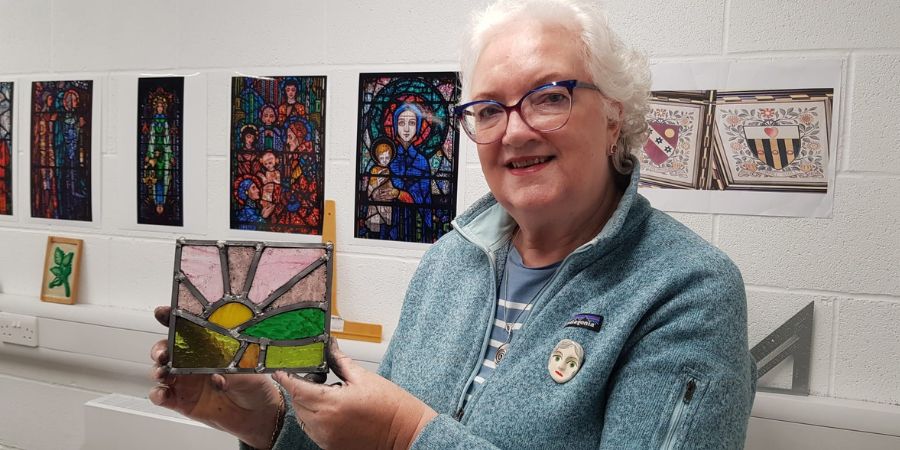 A person holding a piece of stained glass.