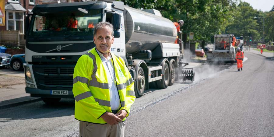 Councillor Shah Wazir at the site of some surface dressing.