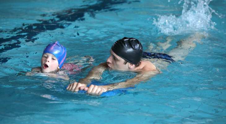 Parent swimming with child.