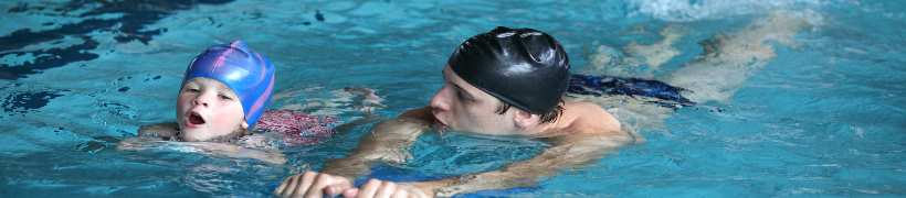 A parent and child swimming.