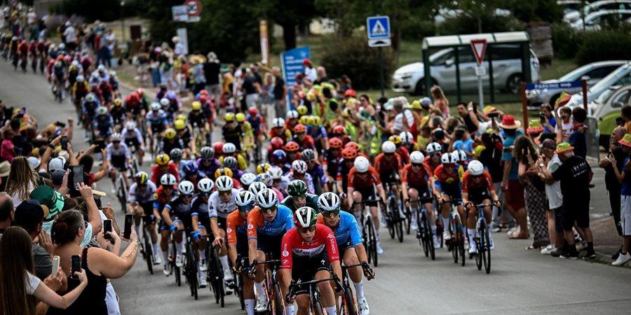 A large group of cyclists in a race, with spectators lining the road and cheering them on. Photo courtesy of A.S.O and Pauline Ballet.