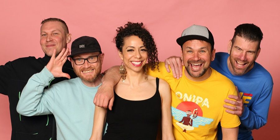 A group of 5 people posing for a photo with a pink background.