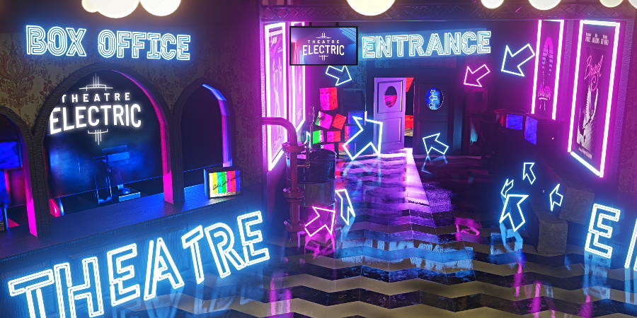 Cinema lobby lit with bright neon signs.