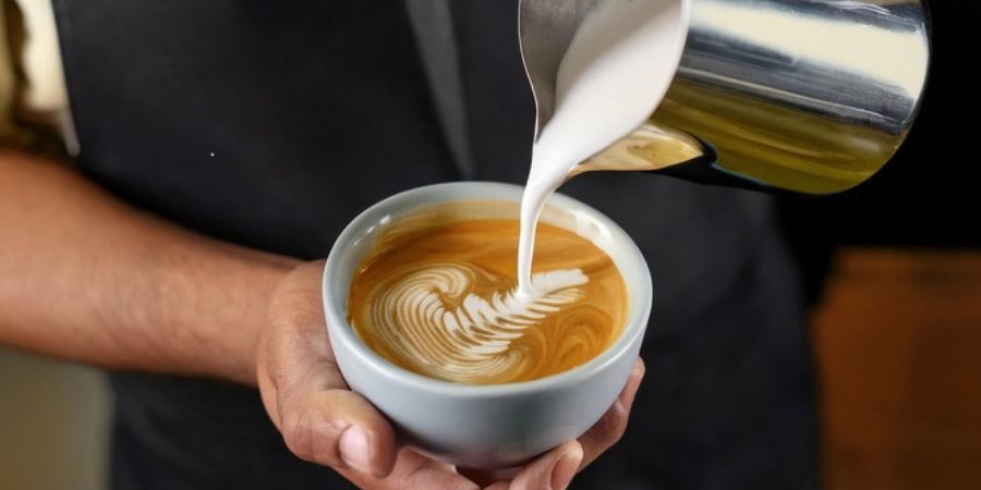 A barista pouring a cup of coffee.