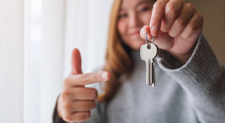 A young person with the keys to their first home.