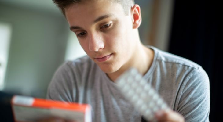 A young person looking at some medication.