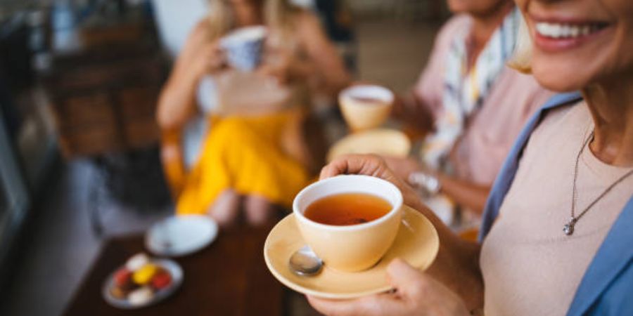 A group of people drinking cups of tea.