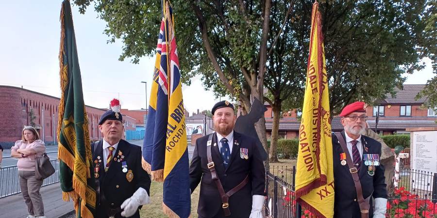 3 veterans with flags.