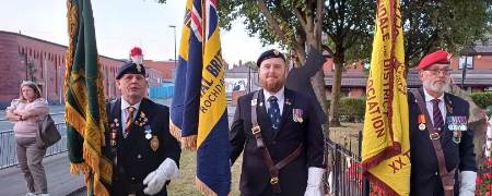 3 veterans with flags at the Castleton Memorial.