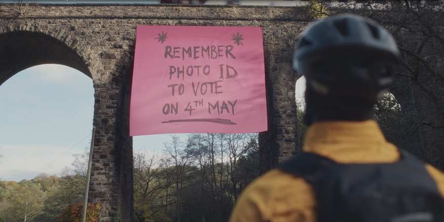 Bridge with large post-it note saying, Remember photo ID to vote on 4th May.