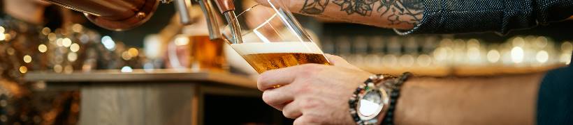 Close-up of hands pulling a pint.