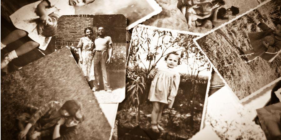 A stack of black and white family photographs.