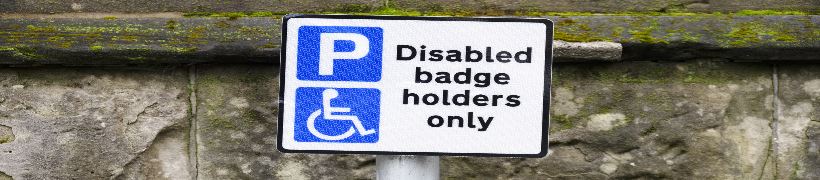 Sign with parking and disability symbols, and text reading, Disabled badge holders only.