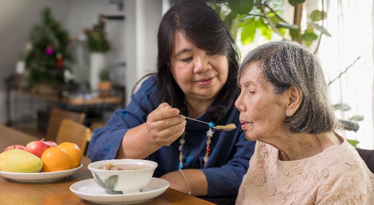 A carer feeding a patient.